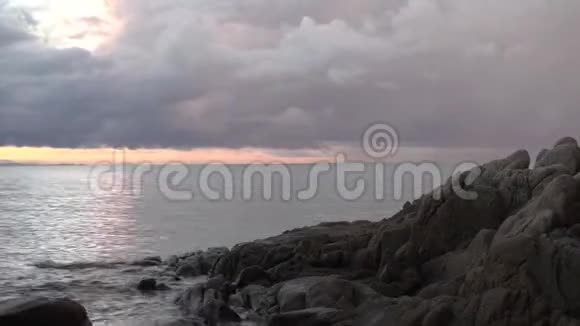 粉色天空在时间点模式拍摄到海洋背景和石头前景视频的预览图