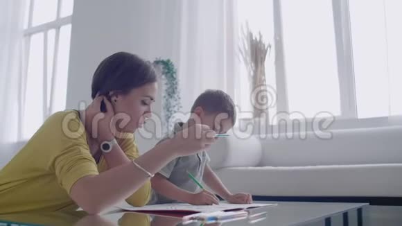 年轻的女人和孩子一起用铅笔画平面视频的预览图