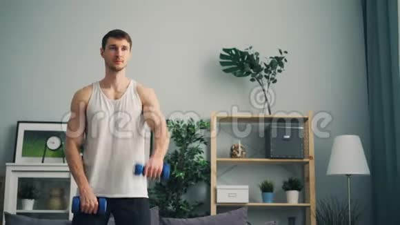 帅哥在家用哑铃锻炼举重训练肌肉视频的预览图