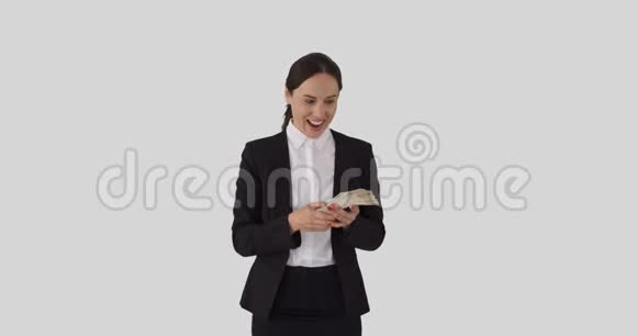 兴奋的女商人闻着现金美元视频的预览图