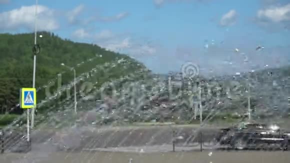 城市的夏日通过喷泉喷水的道路和汽车景观手持射击视频的预览图