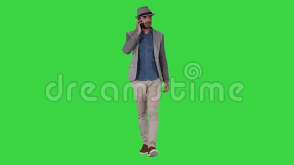 快乐的北非年轻人在绿色屏幕上行走时用手机说话Chroma键视频的预览图