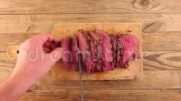 男人用手把切好的烤熟的中熟的烤牛肉用刀翻过来视频的预览图