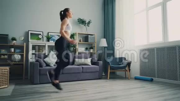 漂亮的女学生在家做练习在平地上当场跑步视频的预览图