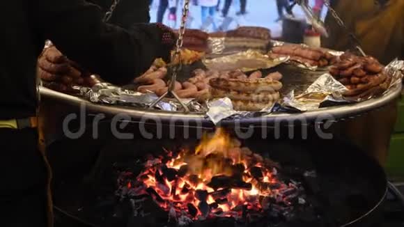 不同类型的烤香肠是在一个巨大的平底锅在明火上炸的视频的预览图