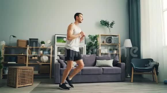穿时髦衣服的漂亮运动员在家做体育锻炼视频的预览图