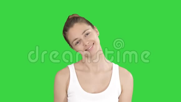 微笑的女人放松她的颈部肌肉做伸展运动的绿色屏幕铬键视频的预览图