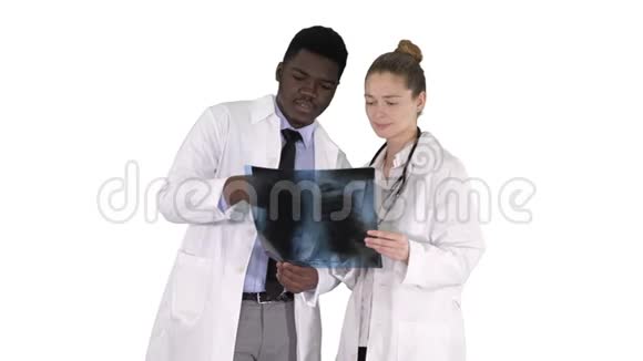年轻的女医生和美国黑人医生看着白色背景下肺的x射线照片视频的预览图