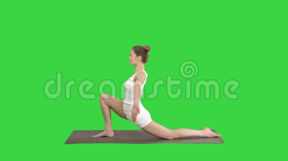 运动迷人的女孩练习瑜伽站在骑手运动中在绿色屏幕上摆一个姿势Chroma视频的预览图