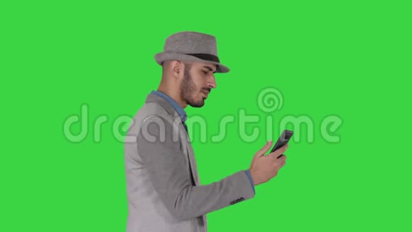 一个男人拿着手机在绿色屏幕上上网用彩色键视频的预览图