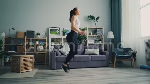 苗条的年轻女士集中精力在轻型公寓的现场跑步锻炼视频的预览图