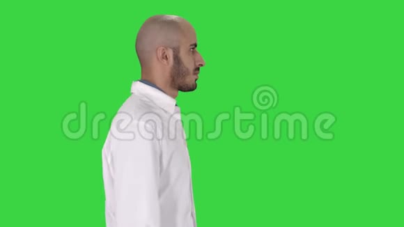 阿拉伯医生穿着白色长袍走在绿色屏幕上Chroma键视频的预览图