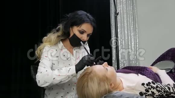 美丽的女性造型师化妆师美容师对躺在特殊位置上的病人进行修眉视频的预览图