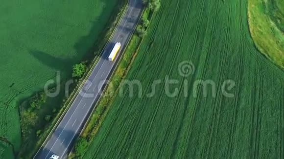 飞机飞越卡车沿着绿色山谷环绕的道路行驶4K视频的预览图