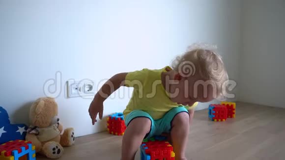快乐的小男孩在家玩五颜六色的积木万向节运动视频的预览图