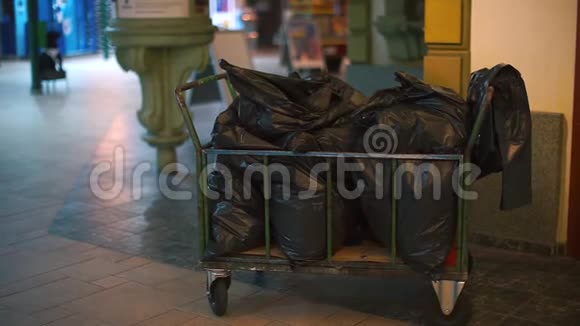 一辆装有黑色垃圾袋的手推车站在酒店的大厅里视频的预览图