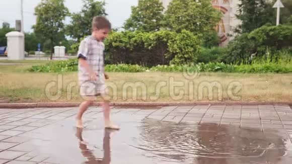 孩子们在公园里玩得很开心在雨后的水坑里赤脚玩耍视频的预览图