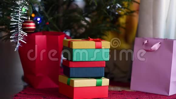 圣诞礼物堆在新年树旁树上挂满了灯视频的预览图
