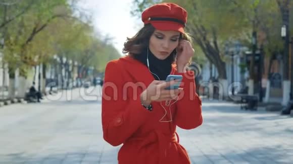 优雅的年轻女孩穿着红色外套在街上自由跳舞很愉快视频的预览图