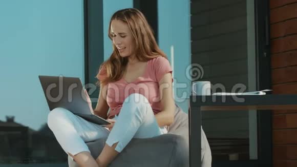 开朗的女人在户外笔记本电脑上谈论SkypeSkype商务谈判视频的预览图