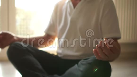 老年瑜伽冥想和修行坐在一起一个坐在莲花位置的人坐在地板上对面是视频的预览图