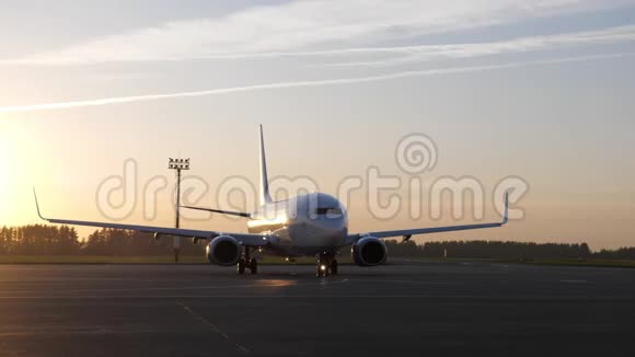 准备飞行的白色大飞机在日落时开始在跑道上移动视频的预览图