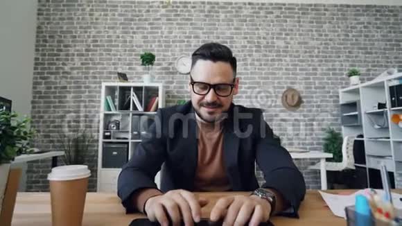 在办公室里用手提电脑打字的英俊男子放大画像视频的预览图