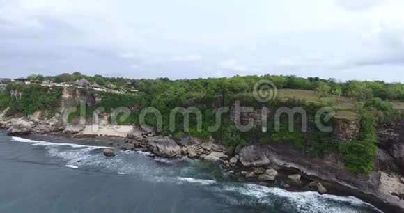 海岸线的空中镜头海滩上有巨大的悬崖和岩石巴厘岛4k视频的预览图