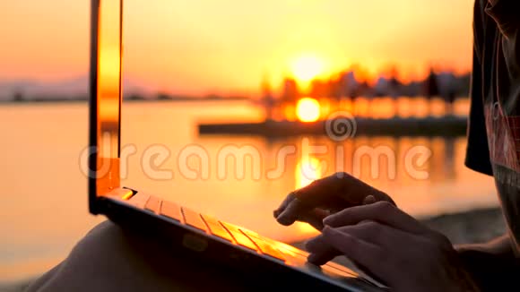 曼斯手在日落背景上敲击笔记本从事自然研究的自由职业者网络连接的质量视频的预览图