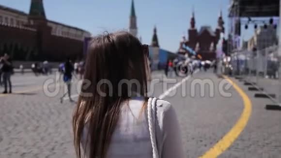 一个女孩在阳光明媚的天气里走来走去一群人经过旅游概念视频的预览图
