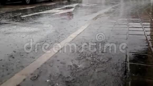 落在城市沥青和人行道上的雨视频的预览图