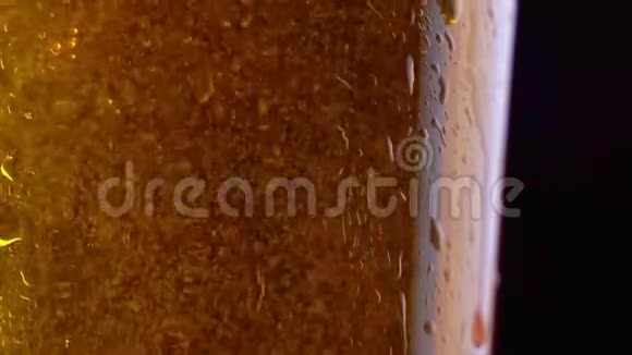 在装有凝结水和水滴的玻璃中加入淡啤酒啤酒杯与啤酒特写一杯冰镇啤酒视频的预览图