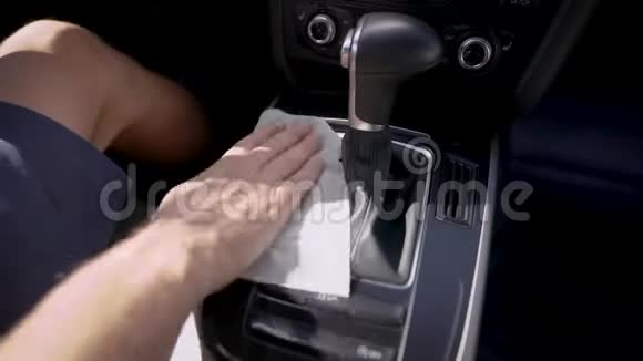 司机正在擦拭汽车齿轮箱面板手拿湿餐巾纸车内特写镜头视频的预览图