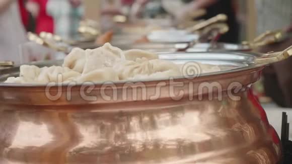 一排锡锅配有皮梅尼大米和其他亚洲食品前景上的Pelmeni被聚焦视频的预览图