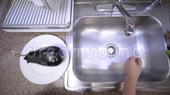 女人正在厨房的水槽里用自来水冲洗番茄视频的预览图