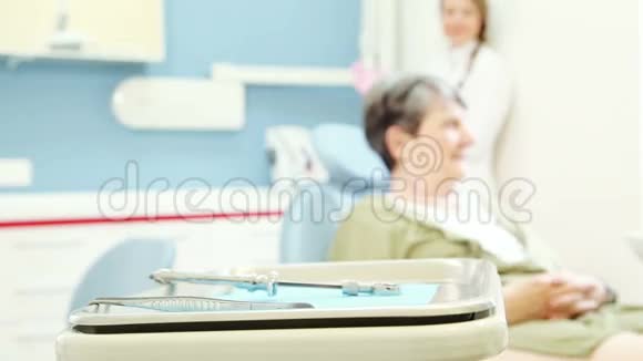 老年女性患者坐在牙科椅上的变焦视频的预览图