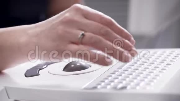 女人按下键盘上的按钮旋转电脑鼠标球调整医疗设备视频的预览图