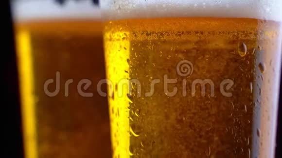 新鲜啤酒手拿一杯美味的工艺啤酒带有水滴气泡和泡沫的冷鲜啤酒视频的预览图