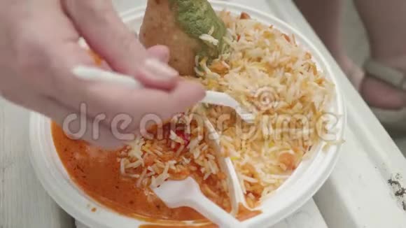 将一次性盘子与尼泊尔菜的聚焦视图关闭人手拿食物用一次性叉子视频的预览图