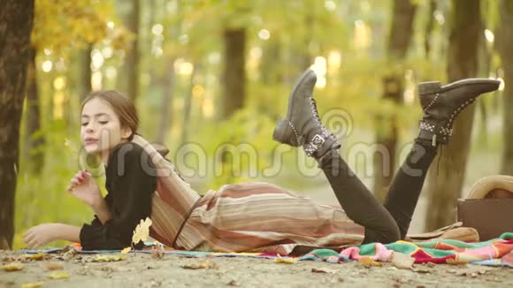 秋天的心情秋天背景下的快乐女人潮人公园里的女模特年轻女性在秋天玩得开心视频的预览图
