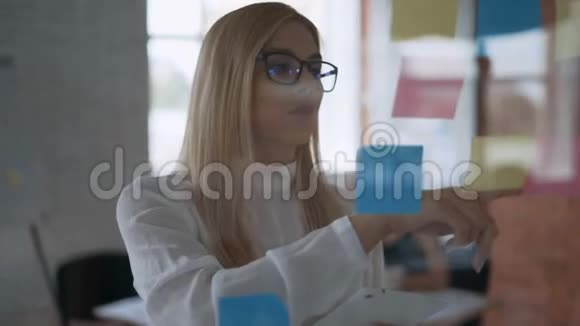 一个成功的女孩中弹严肃的商业女性使用平板电脑和在贴纸上做笔记的肖像视频的预览图