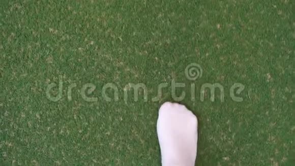 腿的特写脚踩在绿色地板上视频的预览图