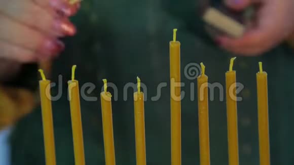 女性手在光明节上点燃蜡烛视频的预览图
