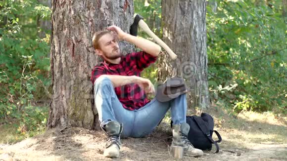 伐木工人在森林里工作有斧头的帅哥强壮的男人穿着格子衬衫拿着斧头的伐木工人伐木工视频的预览图