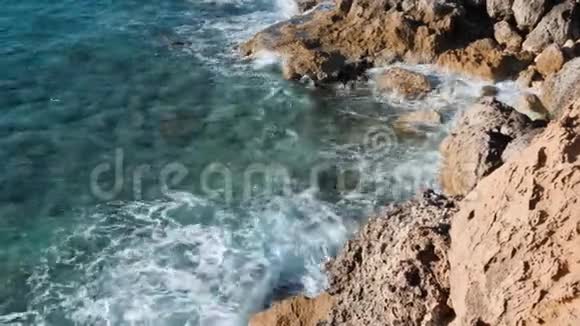 海浪撞击岩石巨大的海浪冲击着悬崖清澈湛蓝的海水和巨大的岩石海岸海滨侧景视频的预览图
