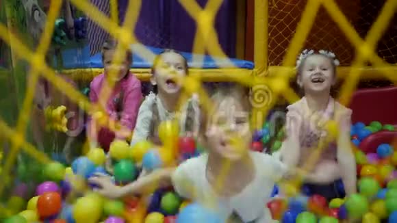 孩子们游戏室幼儿在装满塑料彩球的干盆里玩视频的预览图