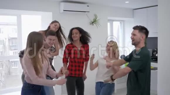 多种族的朋友在慢动作地玩彩纸快乐的年轻男女在家里跳舞和玩视频的预览图