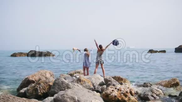 两个迷人的女人在索伦托的石岸漫步欢欣鼓舞视频的预览图