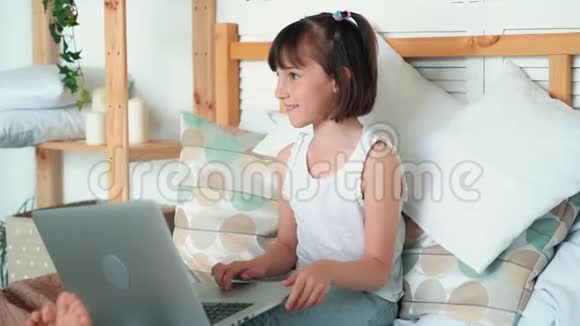 女孩坐在床上用笔记本电脑情绪上说些什么慢动作视频的预览图