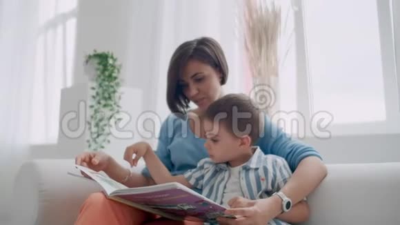 小可爱男孩和妈妈坐在保险箱里看书的肖像视频的预览图